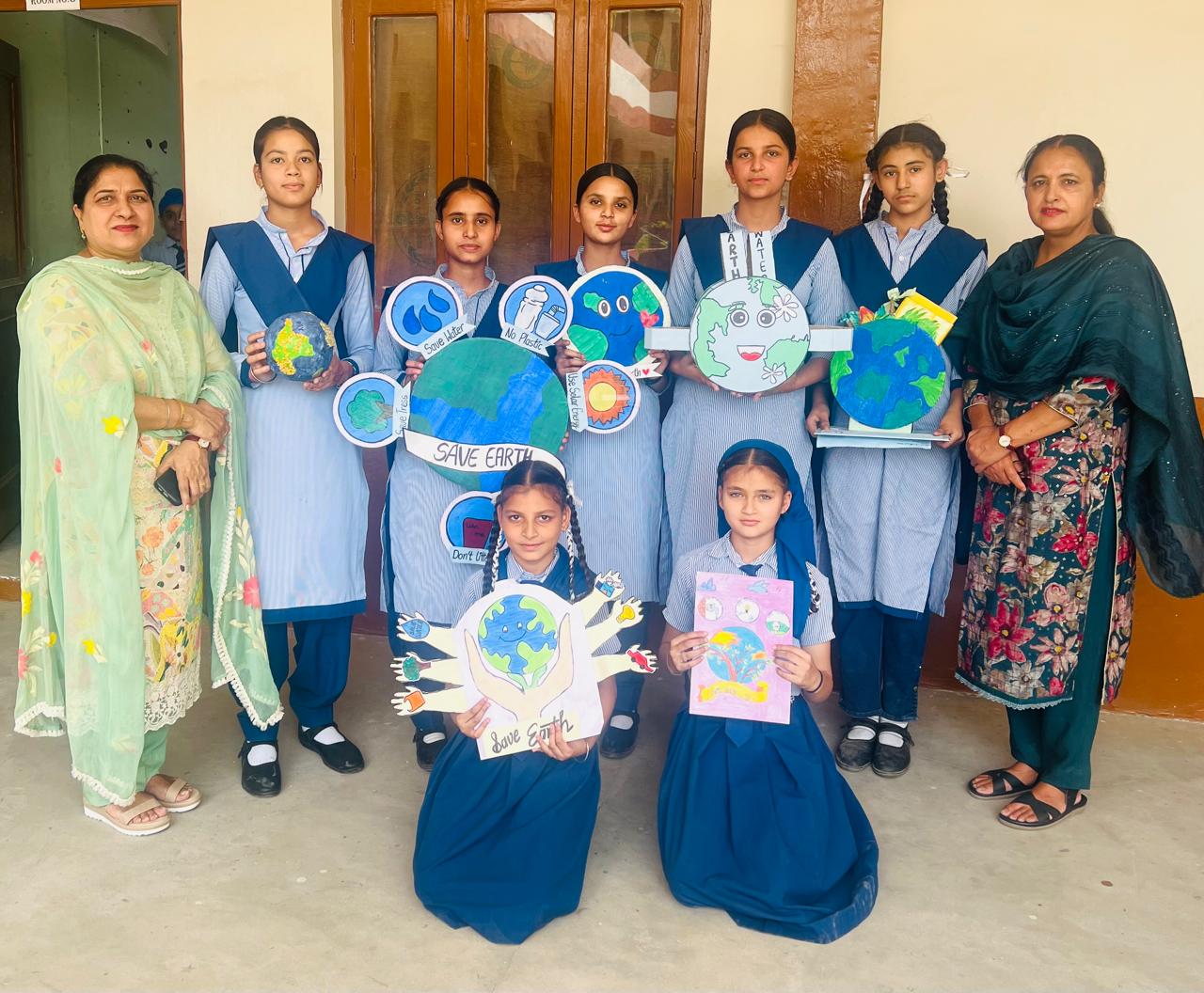 Teachers and students with Earth Day crafts